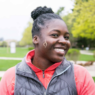 smiling woman with NEDA logo temporary tattoo on her cheek. Click for Campus Warriors.