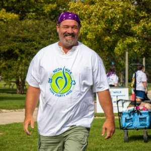 Man smiling with a NEDA t-shirt on