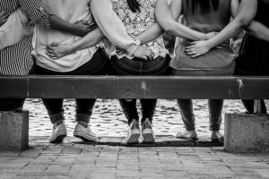 People sitting on bench with back towards camera