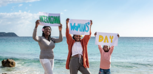 Woman and girls holding International Women's Day Sign
