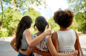 Women hugging with back toward camera